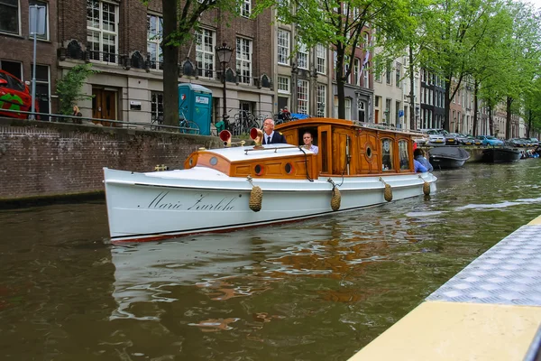 Menschen im Boot auf Touren durch die Kanäle von Amsterdam — Stockfoto