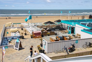 Two young man in beach cafe terrace near the North sea. Zandvoor