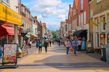 Tourists wakling on the popular shop street Kerkstraat in Zandvo clipart