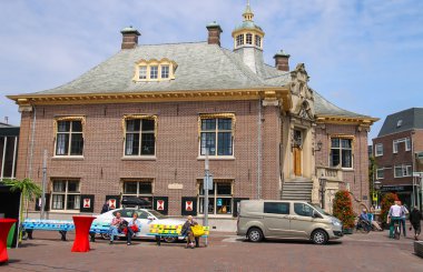 Bankların üzerinde oturan insanlar Zandvoort Belediye Binası, Neth yakınındaki