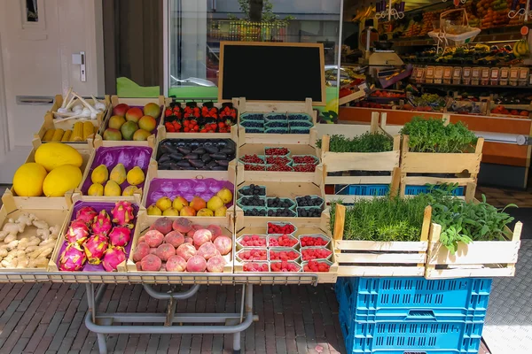 Shelf with fresh fruits and herbs in greengrocery store in Zandv — Stock Photo, Image