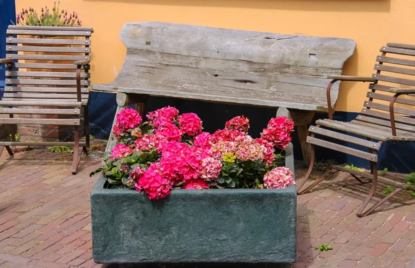 Traditionele straat decoratie met bloemen en houten stoelen in — Stockfoto