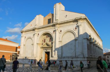 Tourists walking near the ancient Malatestiano Temple (Il Tempio