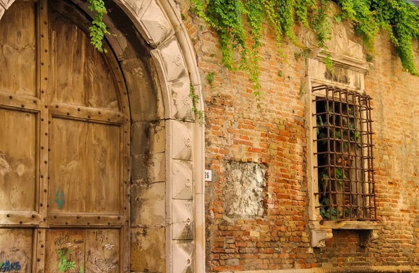 Old wooden door and barred window of ancient building in Rimini, — ストック写真