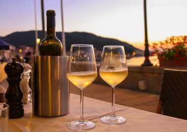 Bir şişe beyaz şarap ve üzerinde Restoran masada iki bardak 