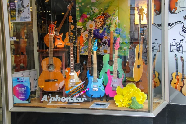 Different types of guitars in the window of the shop of musical