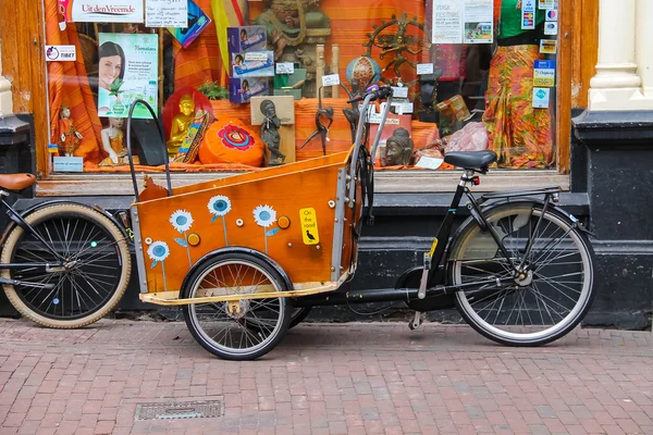 Ljusa trehjuling med en stor bagage korg på Kruisstraat street — Stockfoto