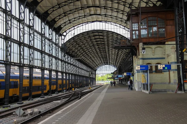 Passageiros esperando por um trem na plataforma na estação ferroviária — Fotografia de Stock