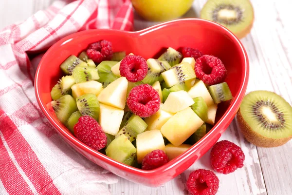 Fruit salad in heart bowl — Stock Photo, Image