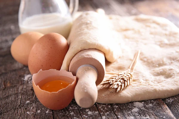 Raw dough and rolling pin — Stock Photo, Image