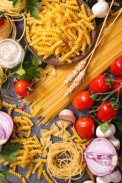 Assorted raw pasta and ingredients — Stock Photo, Image