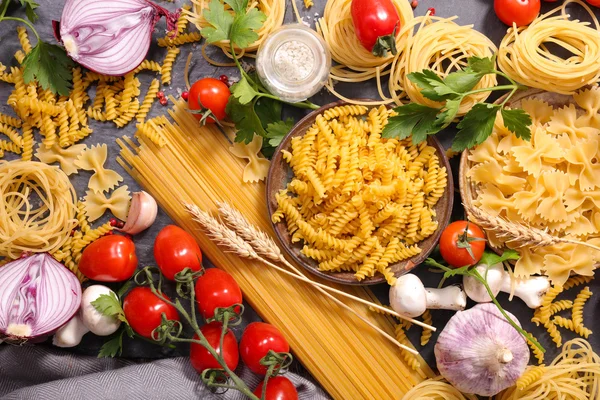 Raw pasta, cherry tomatoes and herbs — Stock Photo, Image