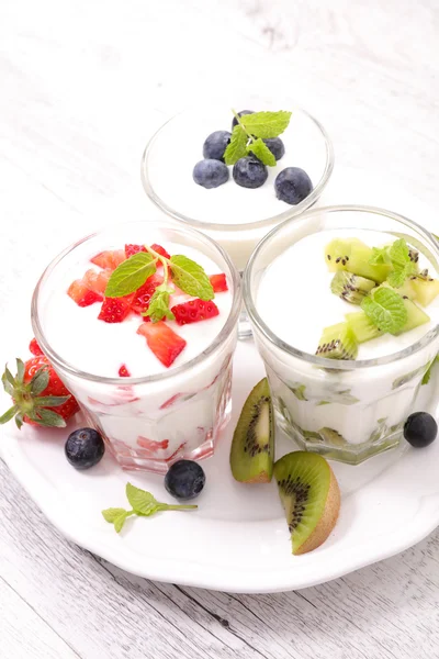 Fruits and yogurt in glasses — Stock Photo, Image