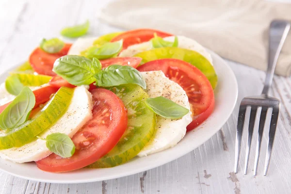 Tomatoes salad with mozzarella and basil — Stock Photo, Image