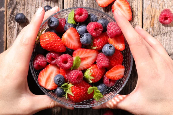 Fruit salad with female hands — Stock Photo, Image