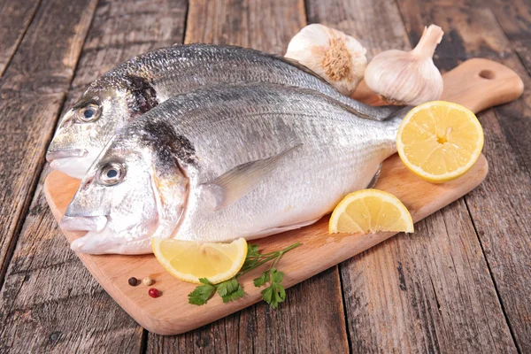 Peixe cru em tábua de cortar — Fotografia de Stock