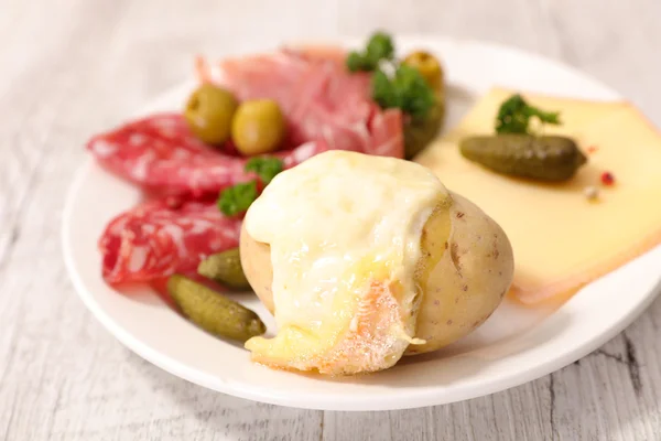 Racletteost smeltet med poteter og kjøtt – stockfoto