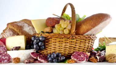 Beyaz arka planda çeşitli peynir ve salam.