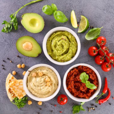Çeşitli vejetaryen humus ve taze malzemeler.