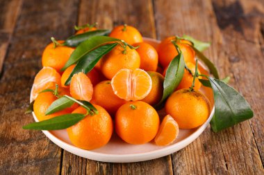 Mandalina ve ahşap arka planda yapraklar