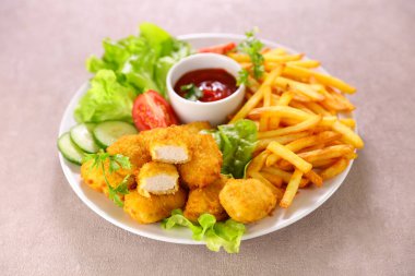 Tavuklu nugget, patates kızartması ve sebze salatası.