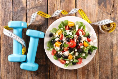 diyet gıda konsepti. Dambıl ve sebze salatası.