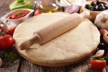 Tahtada malzeme olan pizza hamuru.