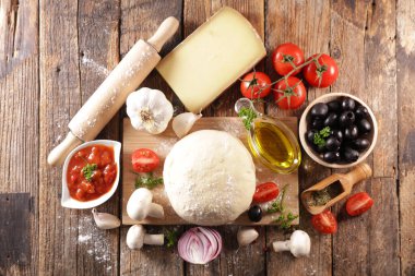 Tahtada malzeme olan pizza hamuru.