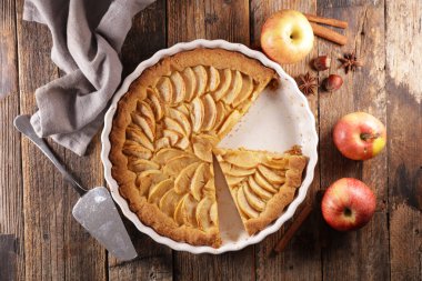 Elmalı turta ve ahşap arka planda baharatlar