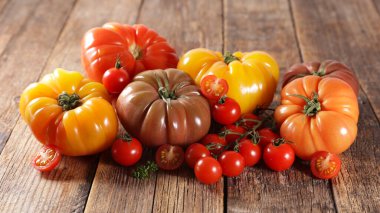 Ahşap arka planda çeşitli domatesler.