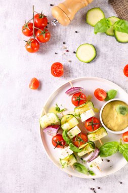 Kabaklı sebze şişi, kiraz domatesi, soğan ve peynir soslu feta.