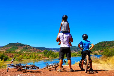 Aile ve bisiklet göl kenarında.