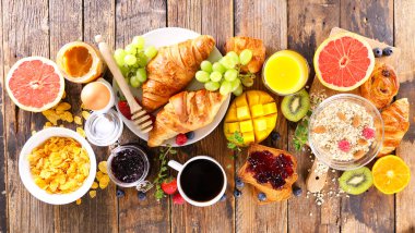 Avrupa kahvaltısı. Kahve fincanı, kruvasan, mısır gevreği ve meyve.