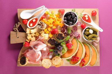 Jambonlu antipasto tabağı, peynir, kanepe, tahtada zeytin.