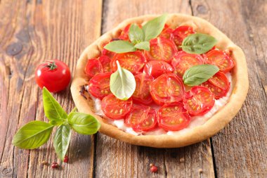 Ahşap arka planda fesleğenli domates kiş.