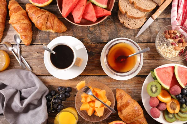 Çay, kahve, kruvasan ve meyveli Avrupa kahvaltısı.