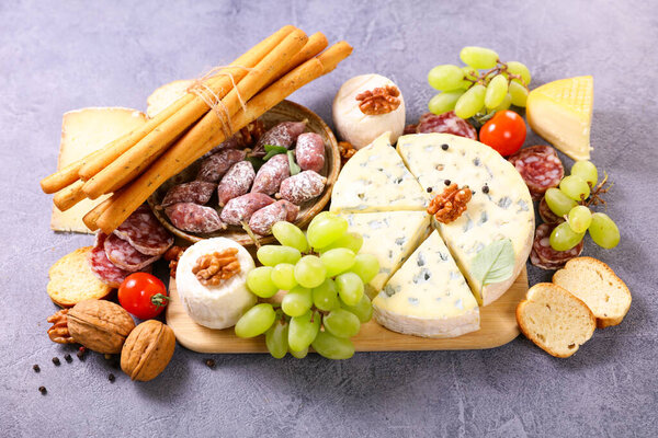 wooden board with cheese and salami