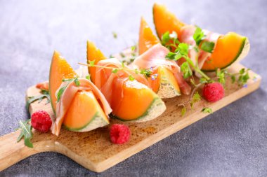 Jambonlu kavun dilimi ve ahududu.