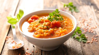 Bir kase mercimek çorbası ve baharat.