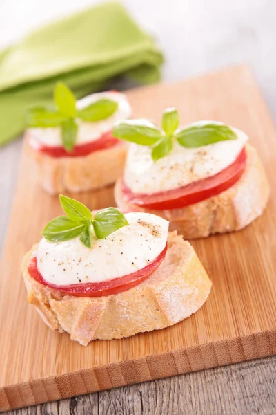 Bröd med tomat, mozzarella och basilika — Stockfoto