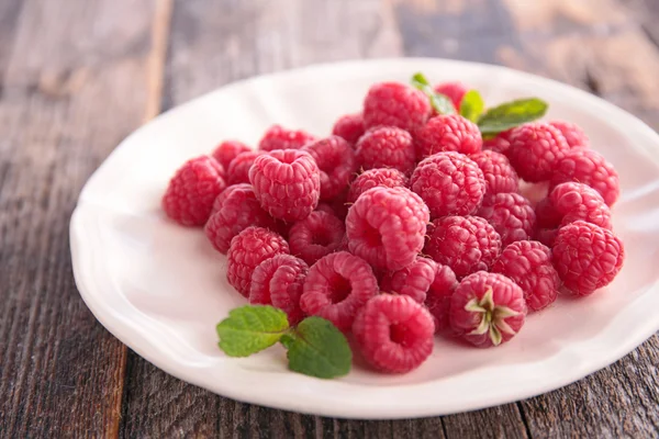 Red ripe raspberries in plate — Stock Photo, Image