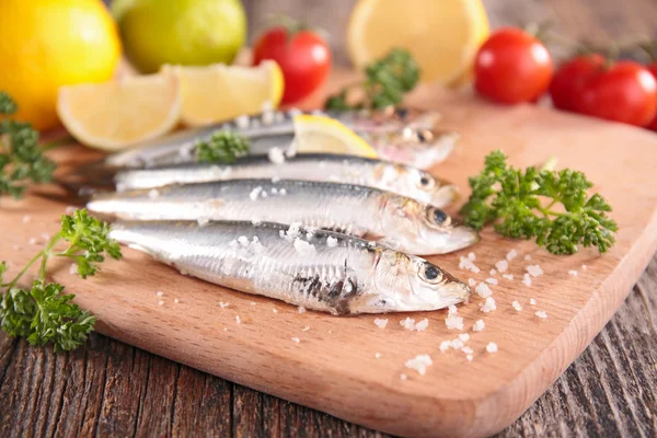 Färska sardiner på träskiva — Stockfoto