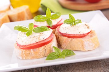 Domates, mozzarella ve fesleğen ekmek üzerinde