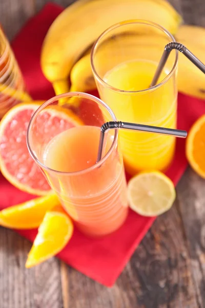 Grapefruit en sinaasappelsap in glazen — Stockfoto