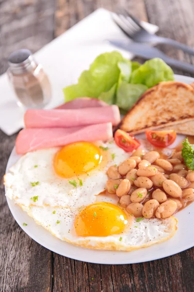 Жареное яйцо, тосты, бекон и бобы — стоковое фото
