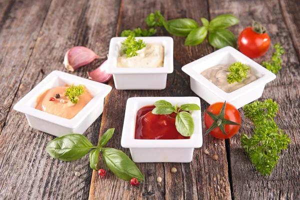 Assortment of sauces with herbs on wood — Stock Photo, Image