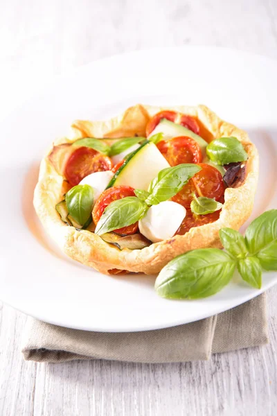 Tomato quiche on plate with vegetables — Stock Photo, Image