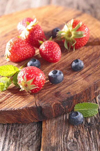 Erdbeeren und Blaubeeren auf Holz — Stockfoto