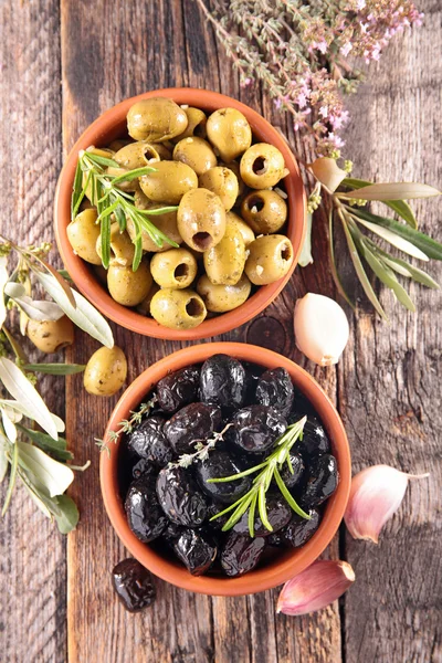 Черные и зеленые оливки с розмарином — стоковое фото