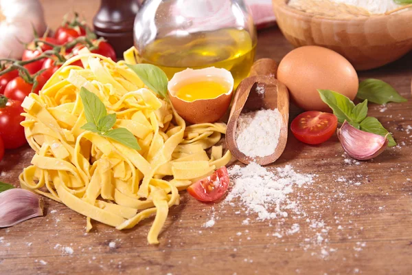 Tagliatelle e ingredientes na mesa — Fotografia de Stock